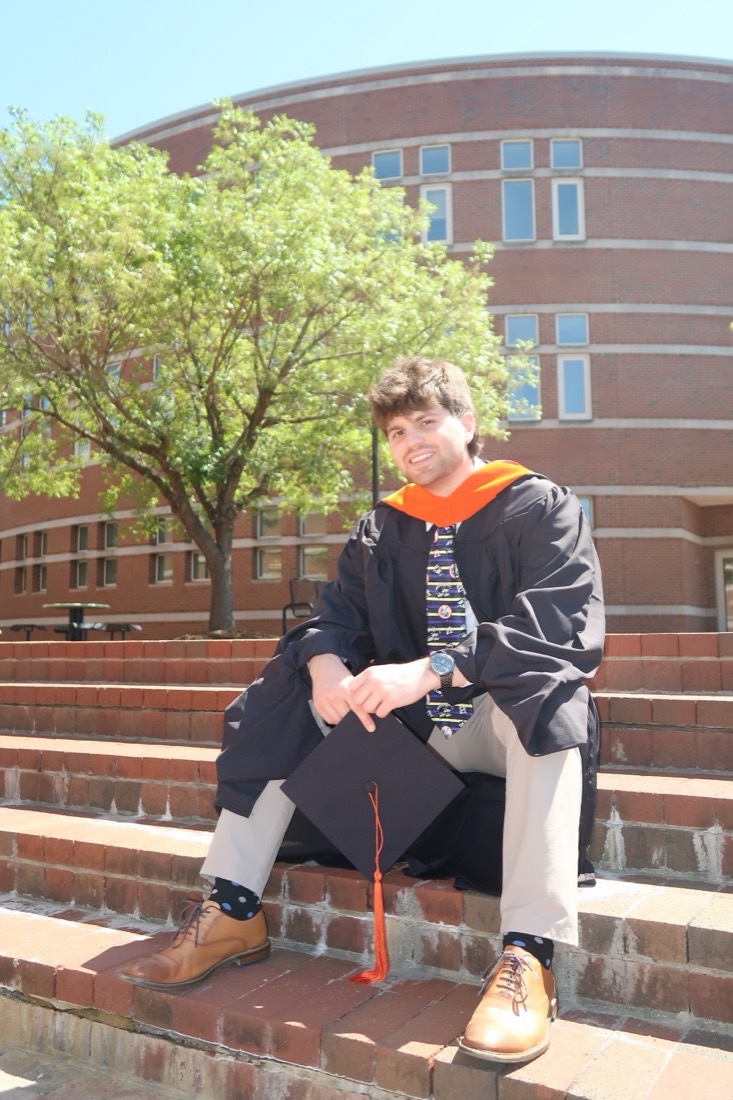 Vincent Buff at his NC State graduation, in master's regalia on campus steps